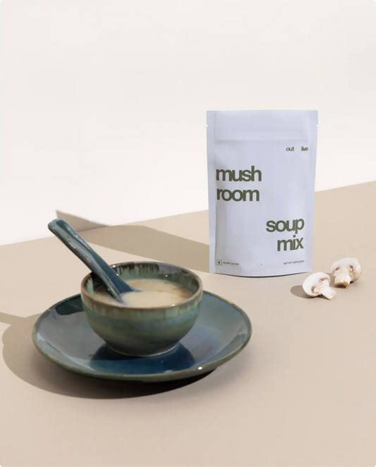 Outlive Mushroom Soup Mix served in a ceramic bowl with a spoon, showcasing its creamy texture. A nutritious meal replacement to support immunity.